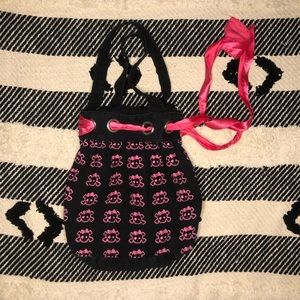 Black bag with pink skulls on the front.